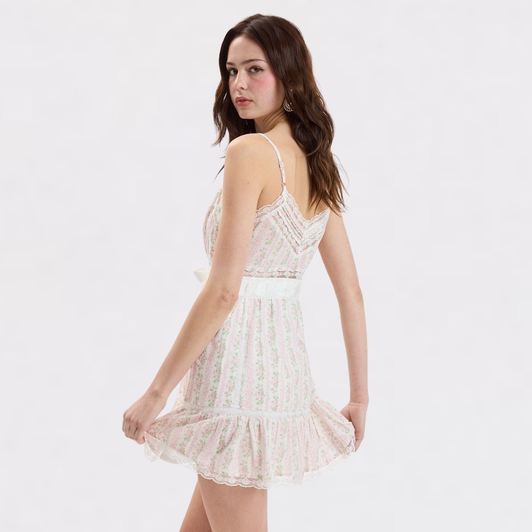 Woman wearing a white lace dress on a plain background