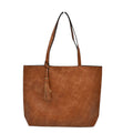 Brown leather tote bag with a tassel on a white background