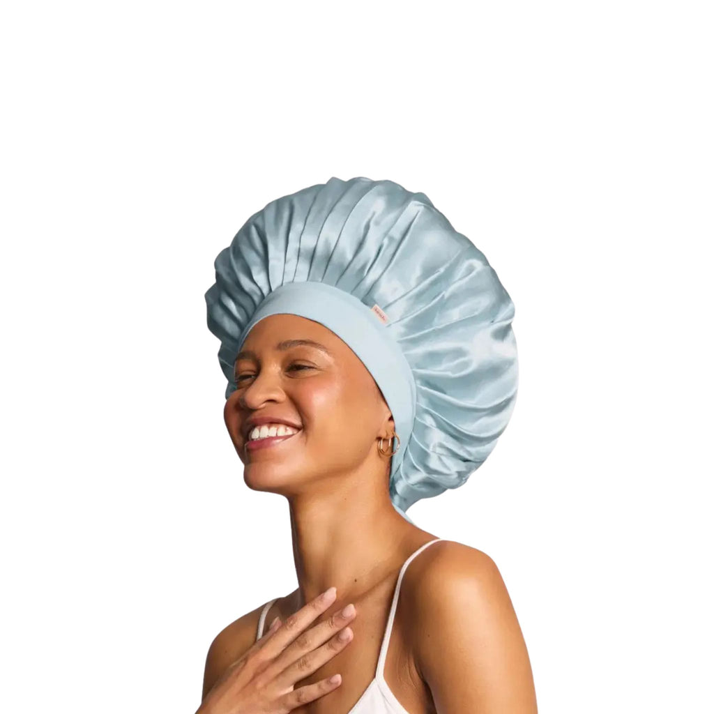 Woman wearing a light blue satin bonnet on a white background