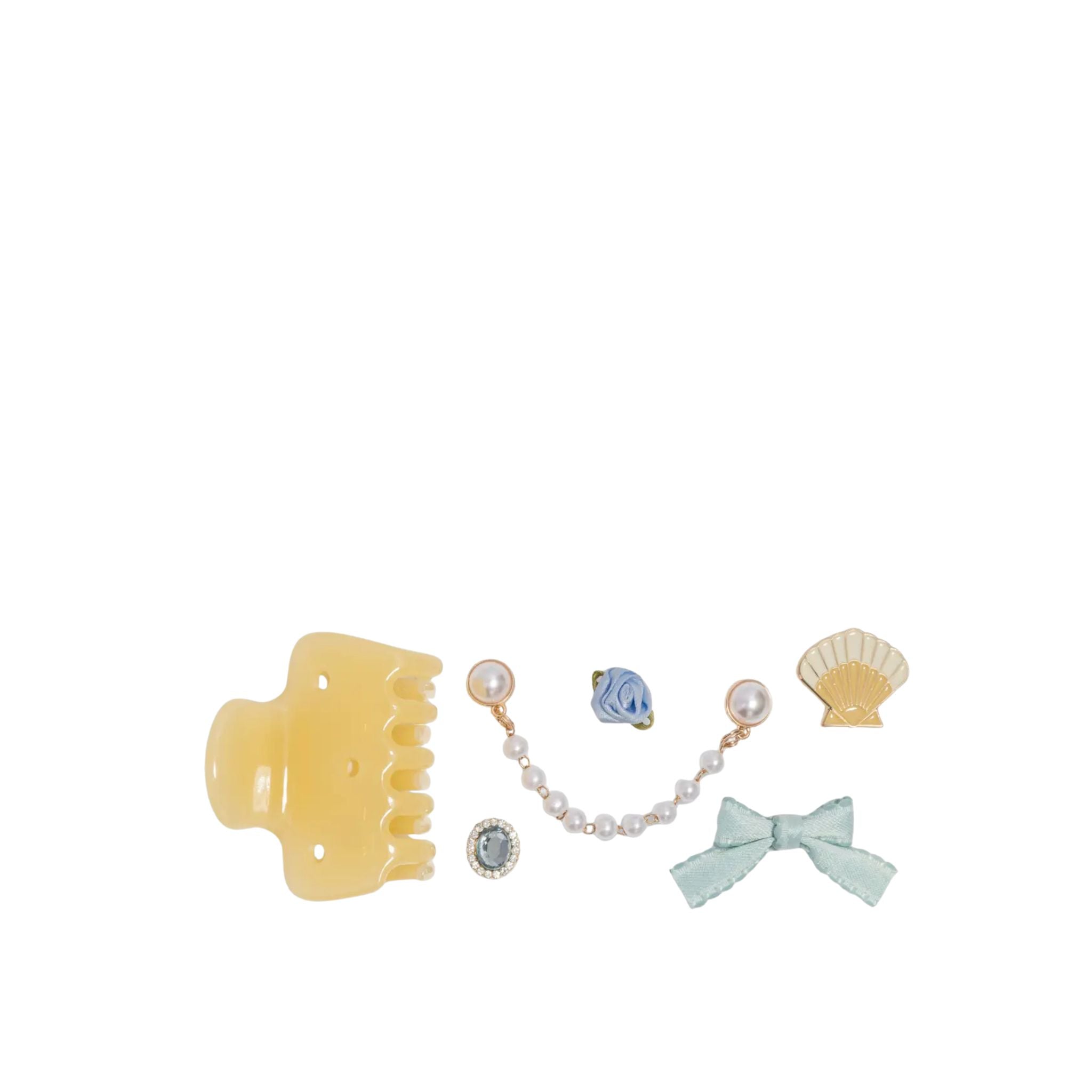 Set of hair accessories including a yellow claw clip, pearl necklace, blue bow, and shell-shaped hair accessory on a white background.