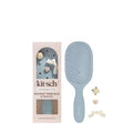 Blue paddle brush with packaging and charms on a white background