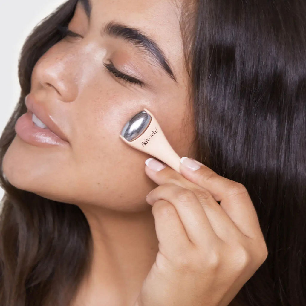 Woman applying makeup with a brush to her face