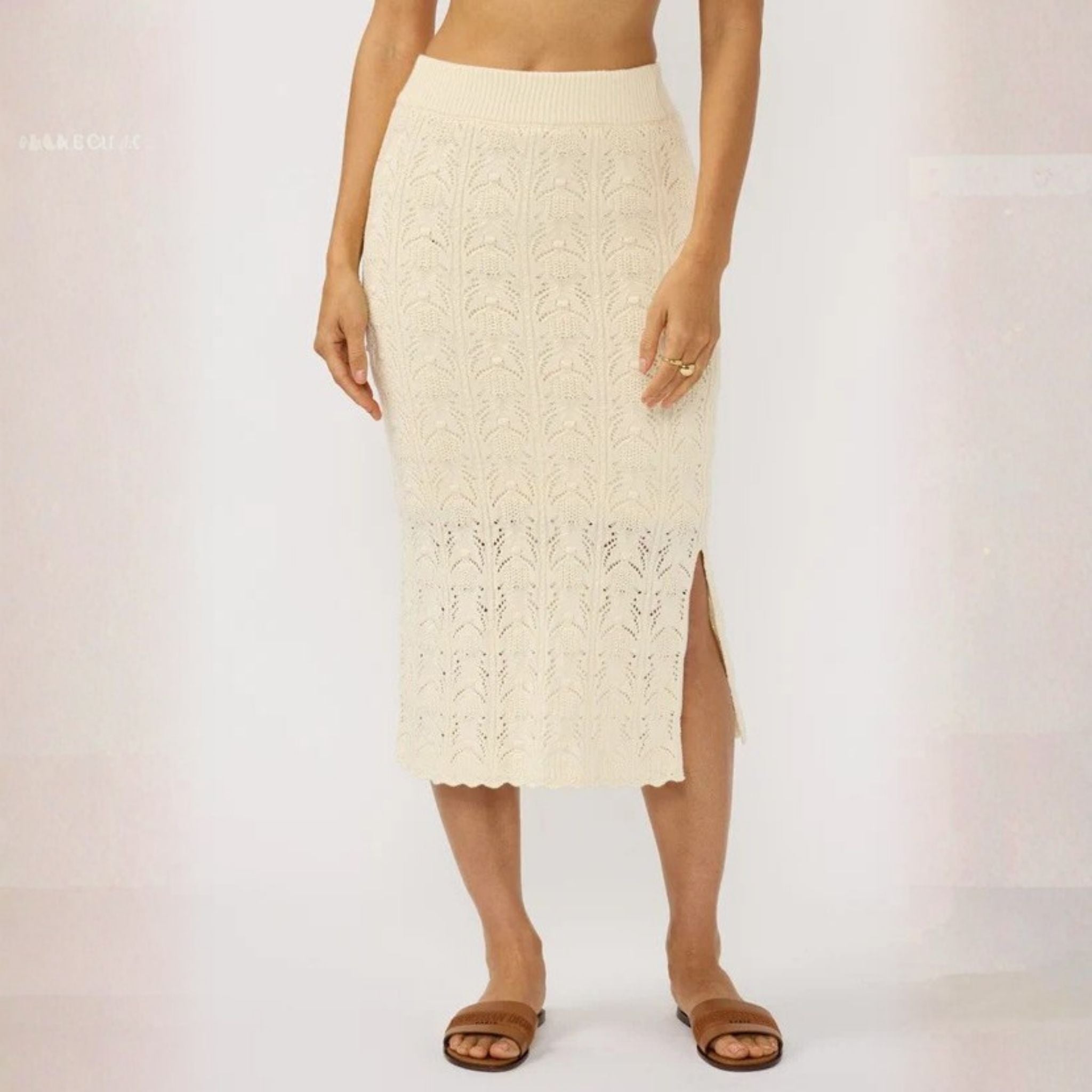 Person wearing a cream lace skirt on a plain background