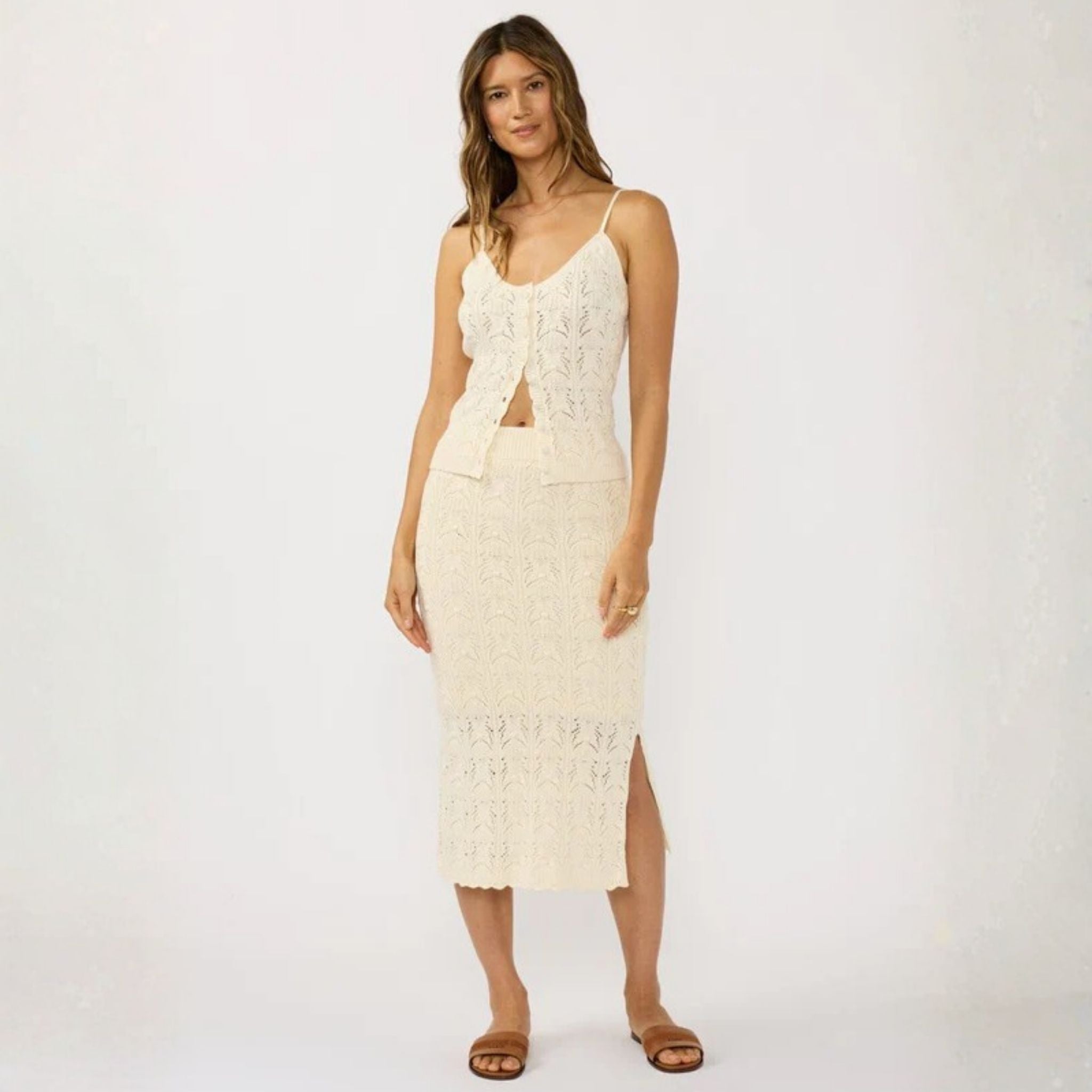 Woman wearing a white lace dress on a plain background