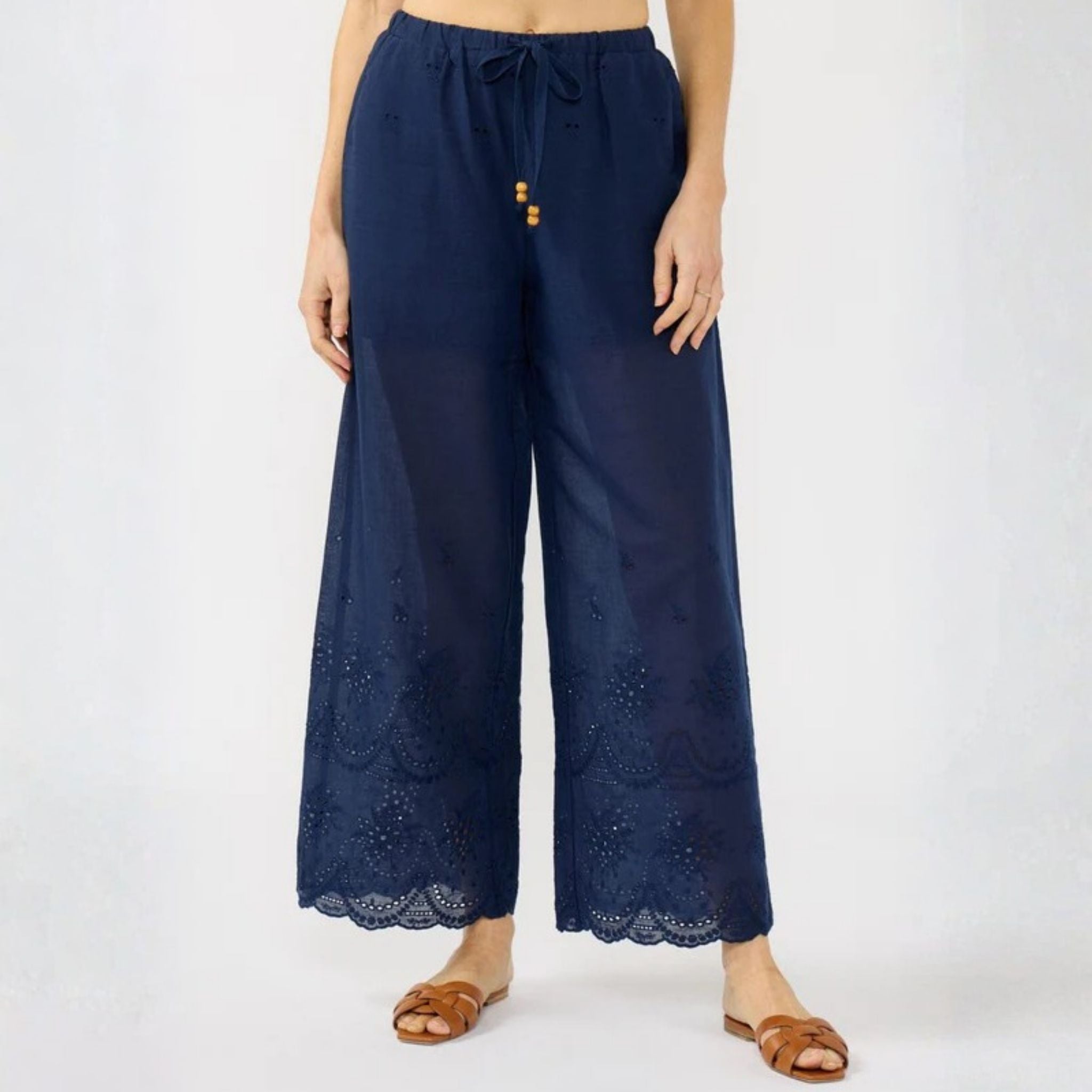 Navy blue lace-trimmed pants worn by a person on a white background