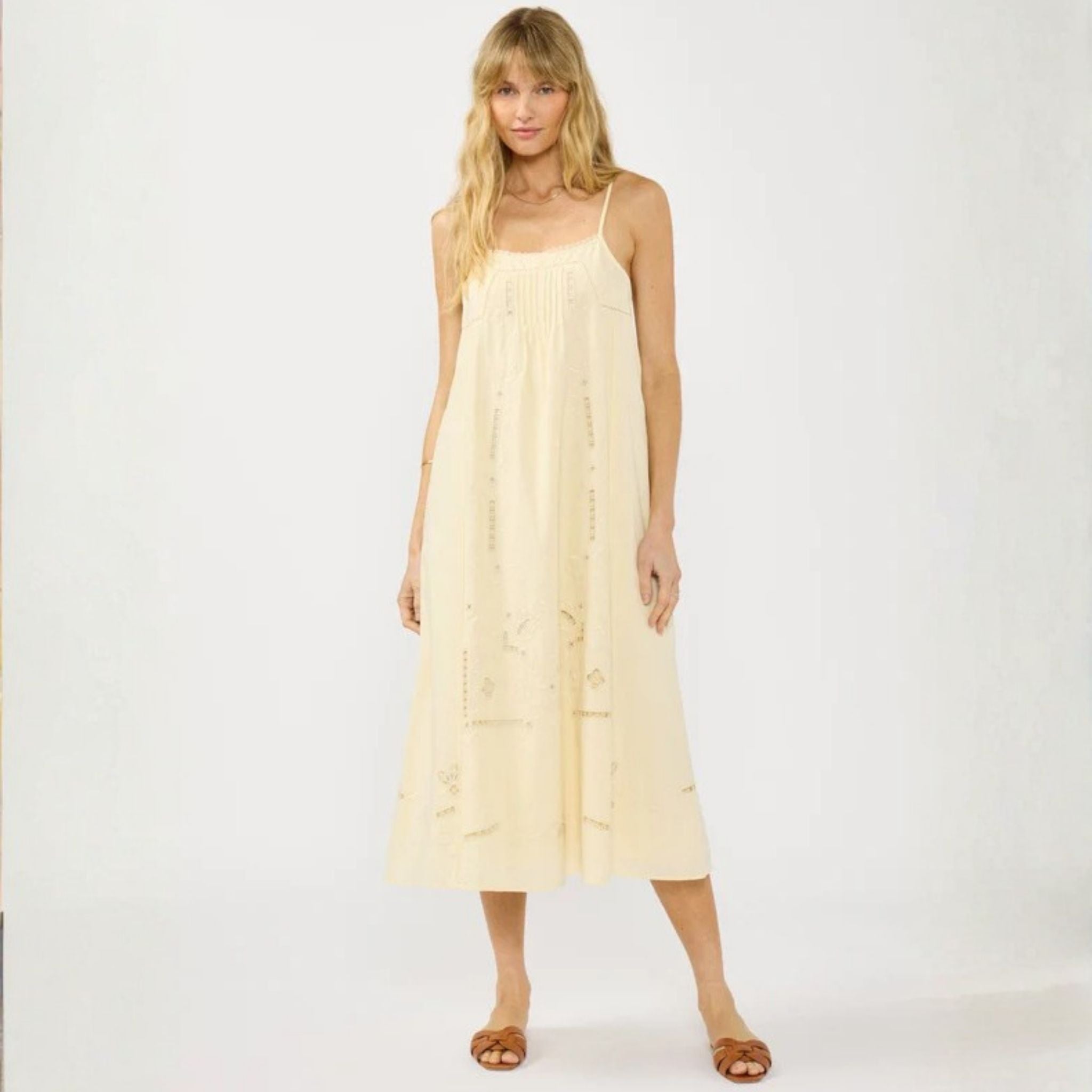 Woman wearing a light yellow dress against a white background