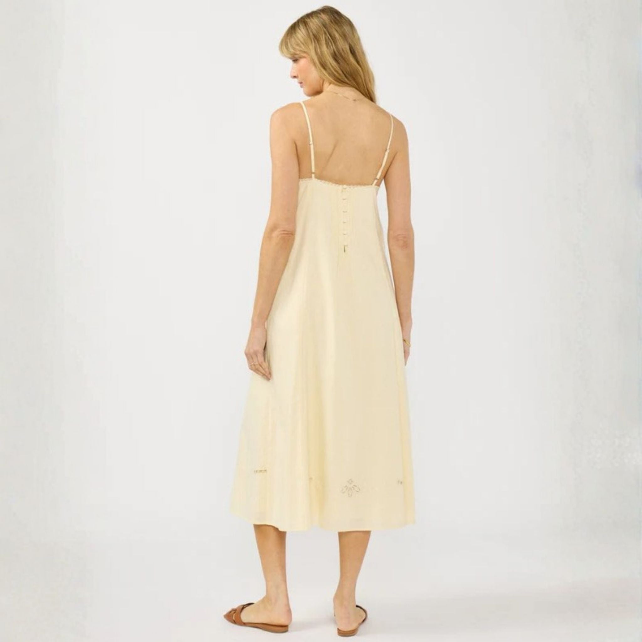 Woman wearing a light yellow dress on a white background