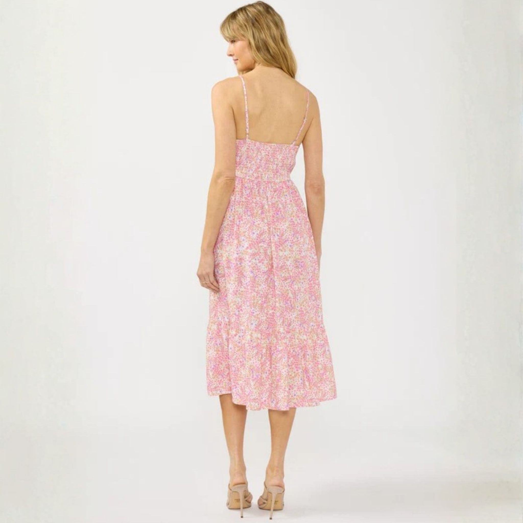 Woman wearing a pink floral dress on a white background