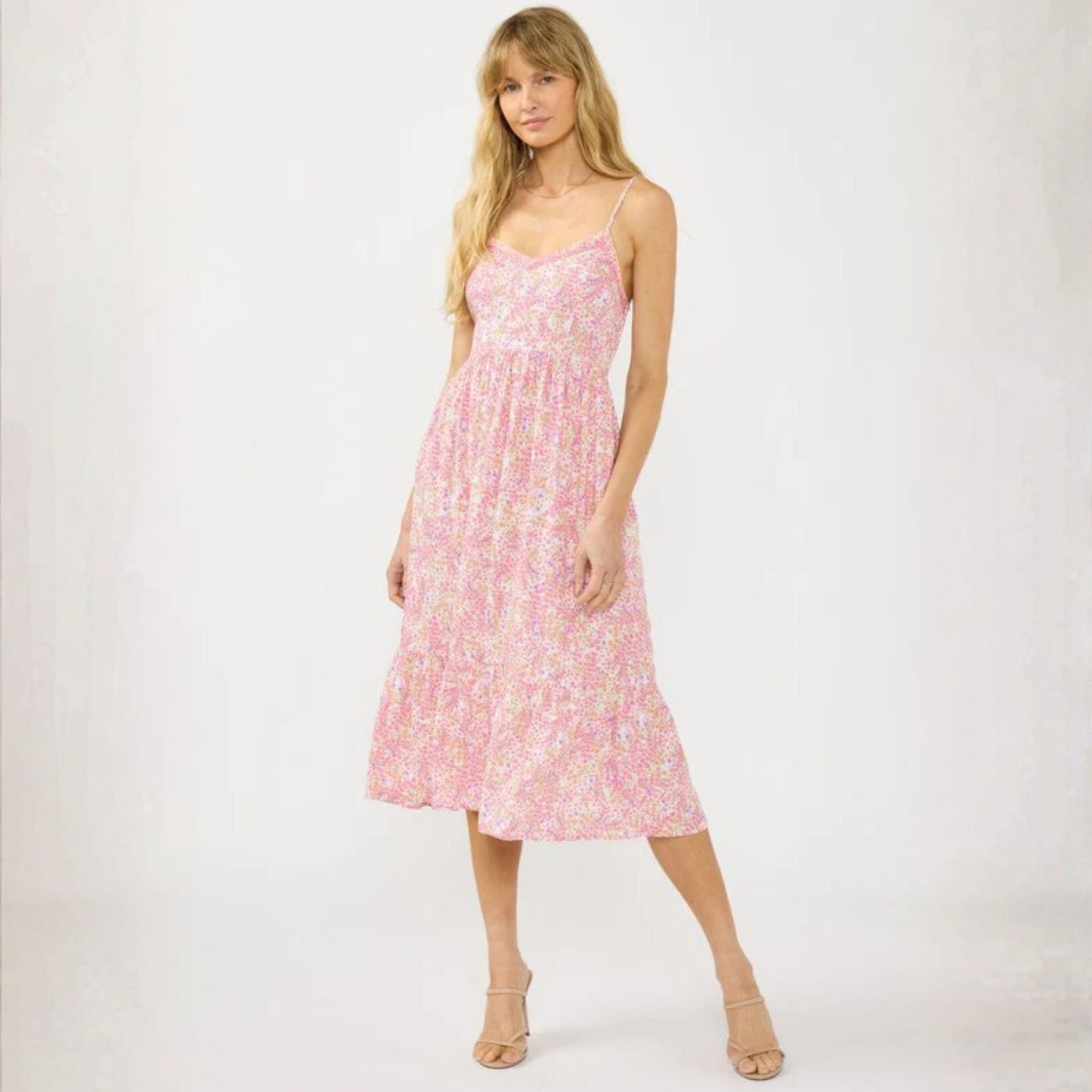 Woman wearing a pink floral dress on a white background