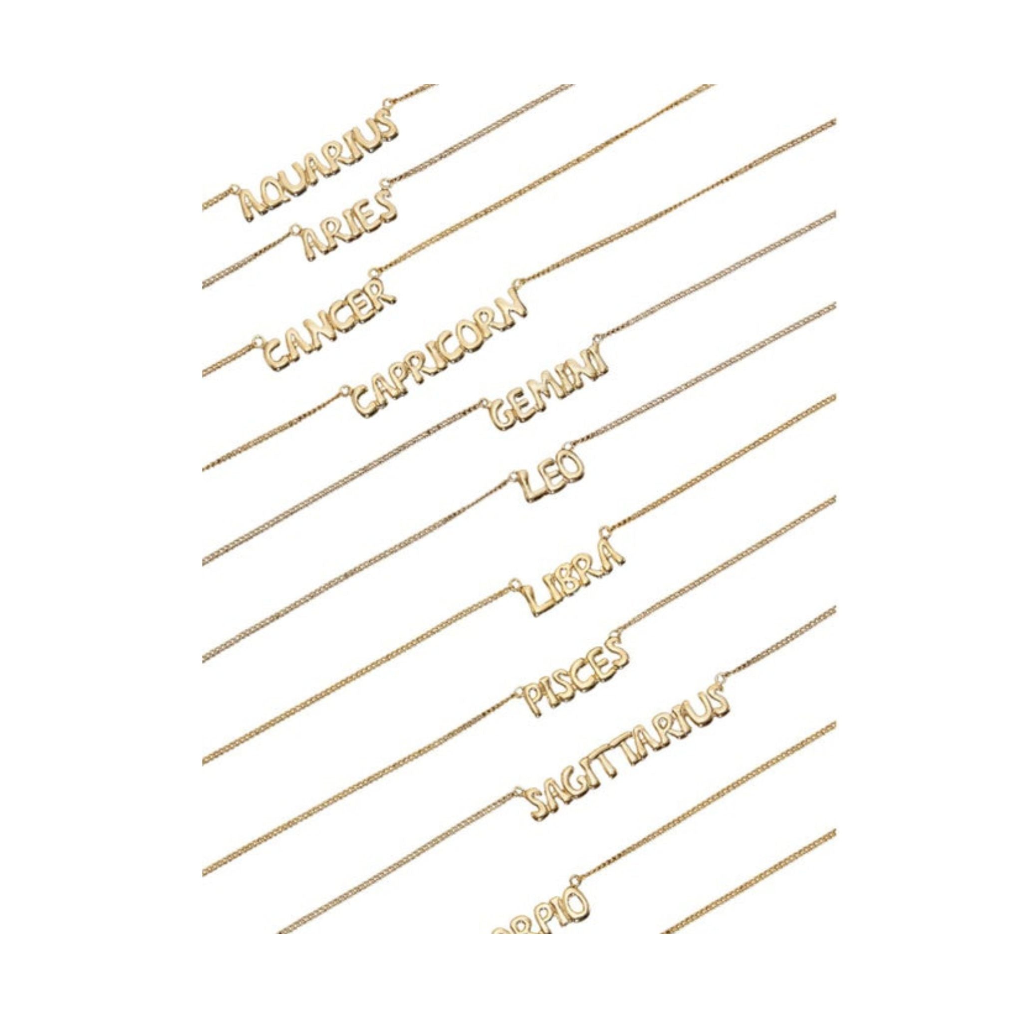 Set of gold necklaces with zodiac signs on a white background