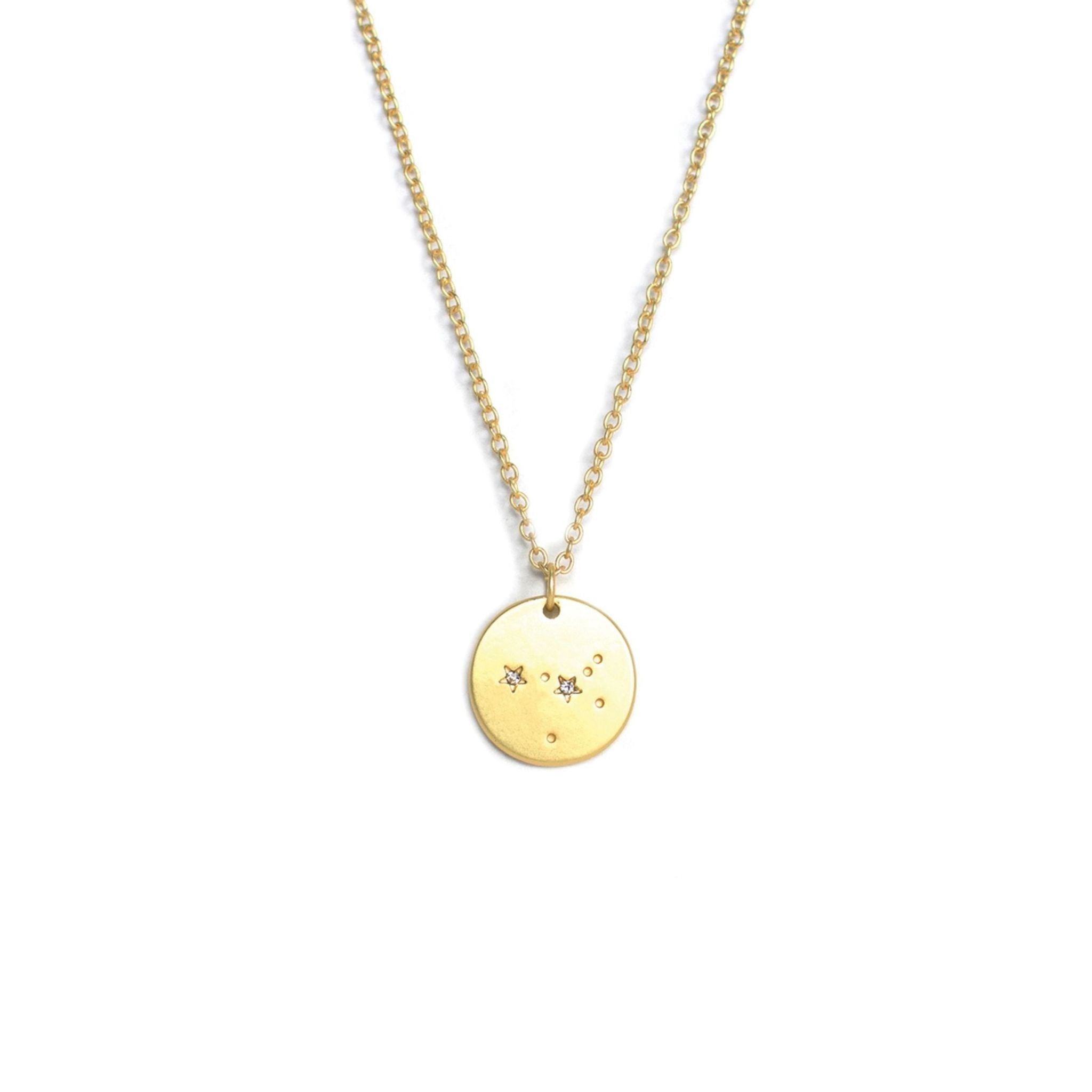 Gold necklace with a round pendant on a white background